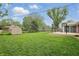 Green backyard featuring a storage shed and spacious deck, perfect for outdoor enjoyment at 4044 Roamin Dr, Greenwood, IN 46142