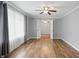 Serene bedroom features hardwood floors, neutral walls, a ceiling fan, and sunlit windows with privacy drapes at 4044 Roamin Dr, Greenwood, IN 46142