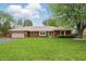 Charming brick ranch home features a well-manicured lawn and attached two-car garage on a sunny day at 4044 Roamin Dr, Greenwood, IN 46142