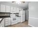 Bright kitchen with white cabinets, white appliances, and wood-look floors at 4044 Roamin Dr, Greenwood, IN 46142