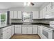 Bright kitchen featuring white cabinets, dark countertops, tile backsplash, and modern appliances at 4044 Roamin Dr, Greenwood, IN 46142