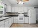 Well-lit kitchen features white appliances, cabinets, and mosaic backsplash at 4044 Roamin Dr, Greenwood, IN 46142