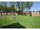 Large backyard with wooden privacy fence, playset, mature trees and lush green space at 4257 Locust Ln, Brownsburg, IN 46112