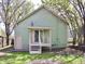 Green two story home with a back yard and deck surrounded by mature trees at 474 N Randolph St, Indianapolis, IN 46201