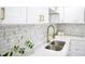 Close up of kitchen, showcasing the tile backsplash, stainless steel sink, and gold hardware at 474 N Randolph St, Indianapolis, IN 46201