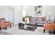 Open living room features a gray sofa, orange chairs, neutral walls, and contemporary artwork at 474 N Randolph St, Indianapolis, IN 46201