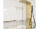 Luxurious shower with modern gold hardware, tile surround, and built-in shelf at 474 N Randolph St, Indianapolis, IN 46201