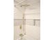 Updated shower featuring white subway tile with pebble accent strip, gold fixtures and rain style shower head at 474 N Randolph St, Indianapolis, IN 46201