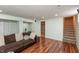 Spacious basement area with wood floors, a large sofa, and access to the upper floors at 480 E Walnut St, Martinsville, IN 46151