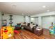 Open basement area with wood floors, a large sofa, and a playset for children to enjoy at 480 E Walnut St, Martinsville, IN 46151