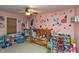 Cozy bedroom with a ceiling fan, pink walls, and colorful flower accents, ideal for a young  at 480 E Walnut St, Martinsville, IN 46151