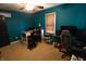 A nicely painted teal bedroom with a fan, a window with blinds, and an office setup at 480 E Walnut St, Martinsville, IN 46151