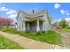 Charming two-story home with a covered front porch, light blue siding, and sidewalk at 524 S State St, Greenfield, IN 46140