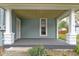 Covered front porch with a door, small window, white pillars and gray painted porch floor at 524 S State St, Greenfield, IN 46140