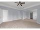 Spacious main bedroom with carpet floors, ceiling fan, light gray paint, and three doors at 524 S State St, Greenfield, IN 46140