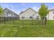 Grassy backyard featuring a black metal fence, complemented by a young tree at 5423 Maywood Dr, Whitestown, IN 46075