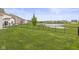 Large backyard with a pond view and black metal fence; perfect for outdoor activities at 5423 Maywood Dr, Whitestown, IN 46075