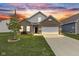 Charming brick home featuring an attached two-car garage and a well-manicured lawn at 5423 Maywood Dr, Whitestown, IN 46075