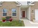 Inviting entrance with brick accents and a charming red front door, accented with lovely landscaping at 5423 Maywood Dr, Whitestown, IN 46075