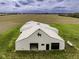 Large white barn with a black horse silhouette and functional garage doors, set against a backdrop of farmland and sky at 5707 S Burlington Dr, Muncie, IN 47302