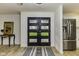 Welcoming entryway with wood-look flooring, a unique door, a mirror on the table, and stainless steel refrigerator visible at 5707 S Burlington Dr, Muncie, IN 47302