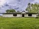 Charming single-story home with white siding, black accents, and a well-manicured front lawn with a cloudy sky above at 5707 S Burlington Dr, Muncie, IN 47302