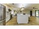 Spacious kitchen featuring a large island, white cabinets, stainless steel appliances, and seamless transition to the dining area at 5707 S Burlington Dr, Muncie, IN 47302