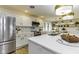 Modern kitchen featuring white cabinets, a stainless steel refrigerator, and an island with white countertop and gold accents at 5707 S Burlington Dr, Muncie, IN 47302