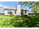 Well-manicured backyard with healthy lawn, chimney, and charming landscaping for outdoor enjoyment at 5809 Scotland St, Indianapolis, IN 46234