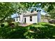 Lush backyard with patio, stone border, manicured grass, and mature trees creating a serene setting at 5809 Scotland St, Indianapolis, IN 46234