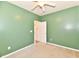Carpeted bedroom painted green with a ceiling fan and an open closet door at 5809 Scotland St, Indianapolis, IN 46234