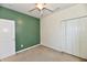 Carpeted bedroom with a green accent wall, ceiling fan, and closet at 5809 Scotland St, Indianapolis, IN 46234