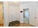Bright entryway featuring wood floors, a white door, and an open view to a carpeted room at 5809 Scotland St, Indianapolis, IN 46234