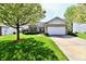 Charming single-story home with a manicured lawn, a stone facade, and an attached two-car garage at 5809 Scotland St, Indianapolis, IN 46234