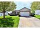 Charming single-story home with a manicured lawn, a stone facade, and an attached two-car garage at 5809 Scotland St, Indianapolis, IN 46234