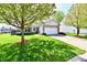 Charming single-story home with a manicured lawn, a stone facade, and an attached two-car garage at 5809 Scotland St, Indianapolis, IN 46234