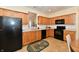 Bright kitchen featuring oak cabinets, modern black appliances, and a tile backsplash and flooring at 5809 Scotland St, Indianapolis, IN 46234