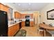 Open kitchen with oak cabinets, black appliances, tile floor, and a cozy breakfast nook at 5809 Scotland St, Indianapolis, IN 46234