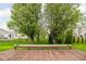 Spacious wooden deck overlooking a grassy backyard with mature trees and distant houses at 5864 Mustang Ter, Plainfield, IN 46168