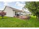 Grassy backyard with a wooden deck featuring a grill and lush landscaping for outdoor enjoyment at 5864 Mustang Ter, Plainfield, IN 46168