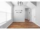 Bright dining room boasts modern chandelier, decorative shelves, and beautiful wood floors at 5864 Mustang Ter, Plainfield, IN 46168