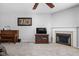 Cozy living room with a fireplace, plush carpet, a ceiling fan and a wooden cabinet at 5864 Mustang Ter, Plainfield, IN 46168