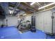 Finished basement gym area with blue floors, workout equipment, and exposed ceiling at 5925 Silas Moffitt Way, Carmel, IN 46033