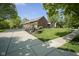 Well-manicured front yard showcases a brick home with a long driveway, beautiful landscaping, and mature trees at 5925 Silas Moffitt Way, Carmel, IN 46033