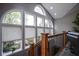 Bright staircase landing featuring many windows, wood railing, and slate-look floor tiles at 5925 Silas Moffitt Way, Carmel, IN 46033