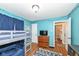 Bright bedroom featuring bunk beds, blue walls, and hardwood floors at 6167 Ralston Ave, Indianapolis, IN 46220