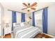 Bedroom with striped bedding, blue curtains, and hardwood floors at 6167 Ralston Ave, Indianapolis, IN 46220