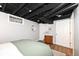 Finished basement bedroom featuring a dresser, exposed piping, and painted ceiling at 6167 Ralston Ave, Indianapolis, IN 46220