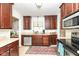 This kitchen features dark wood cabinets, stainless appliances, and a charming area rug at 6167 Ralston Ave, Indianapolis, IN 46220