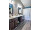 Bathroom with dual sink vanity, dark wood cabinets, and shower-tub with curtain and wood-look floors at 623 White Ash Trl, Mooresville, IN 46158